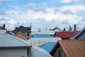 A collection of standing seam metal roof colors and textures, featuring samples in charcoal, bronze, forest green, and slate grey to showcase available design options